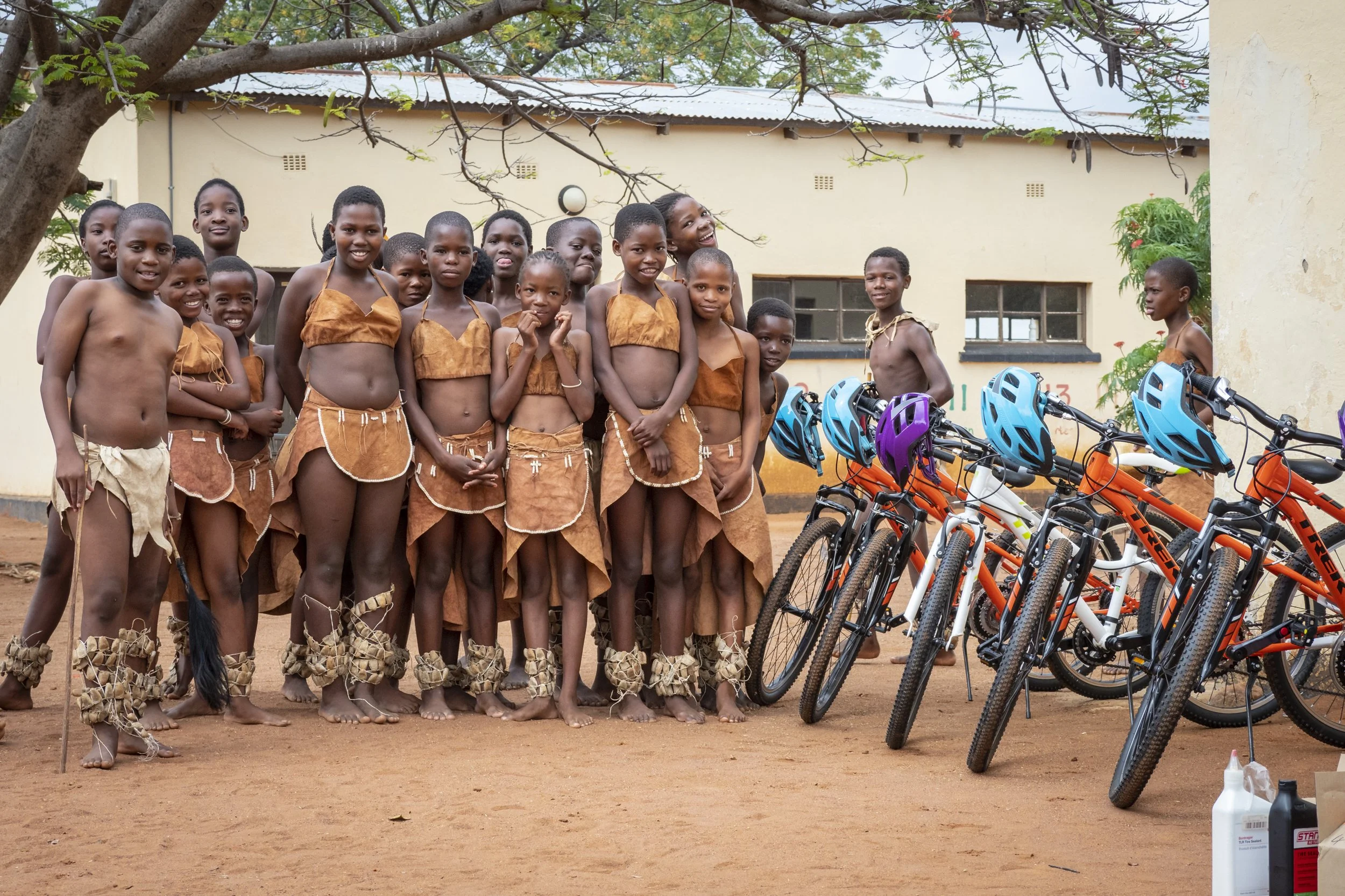 Kids dressed in traditional wears eye up some sweet mountain bikes. Photo Ben Haggar.