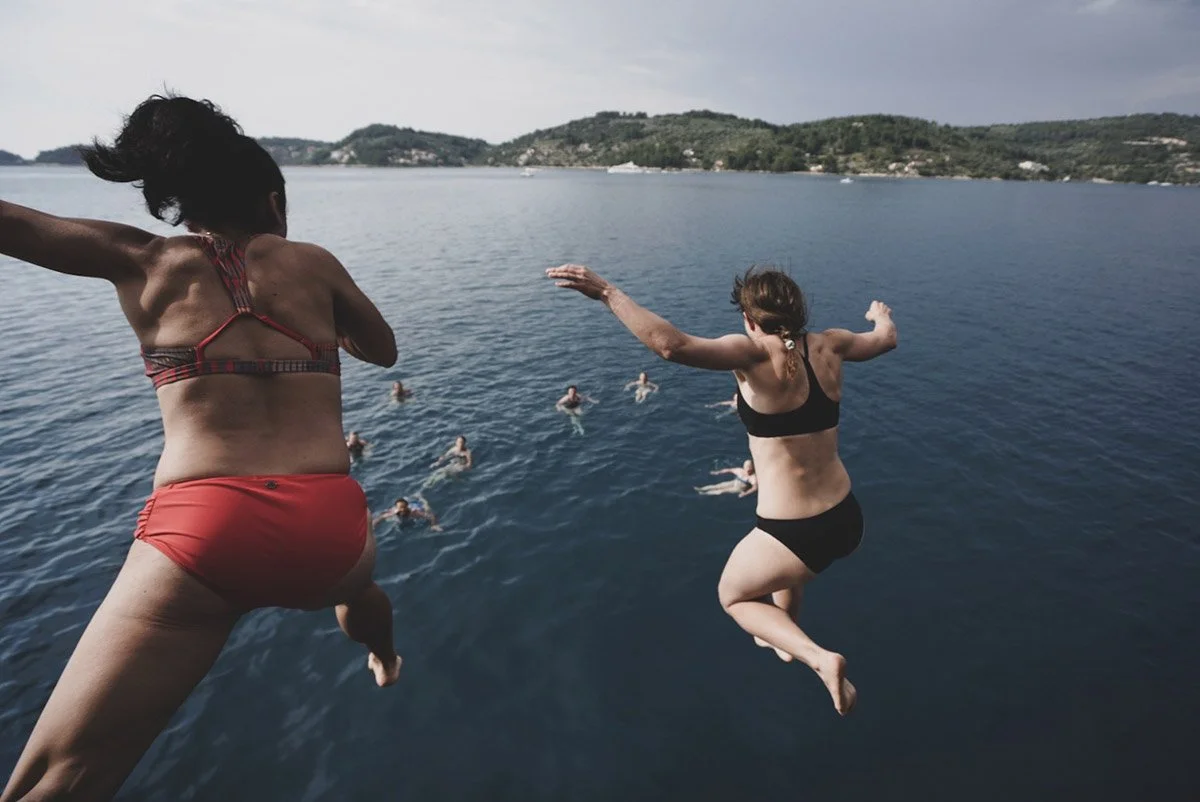 bikers jumping from boat in to the water in croatia