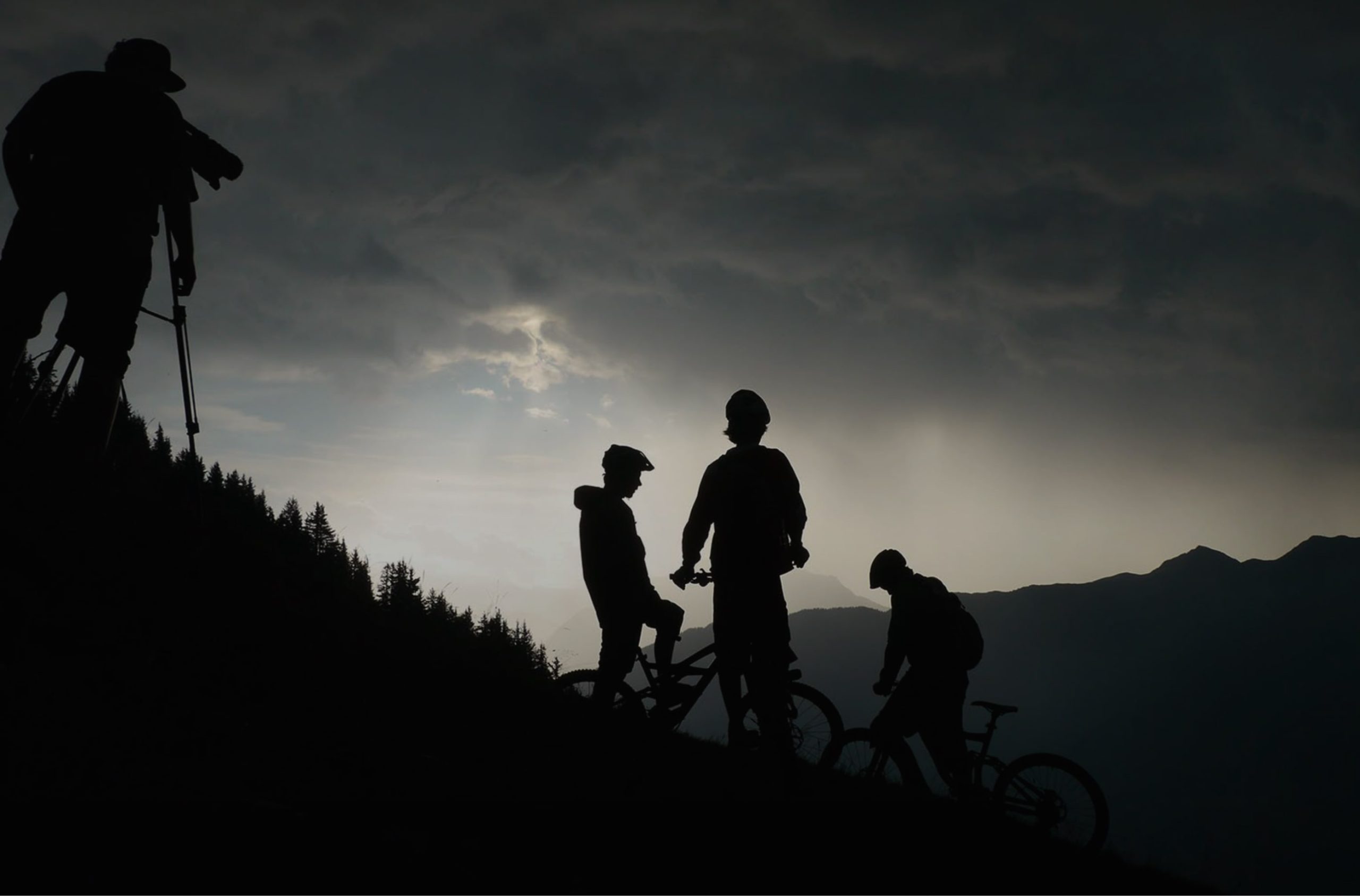 silhouette of mountain bikers on a mountain