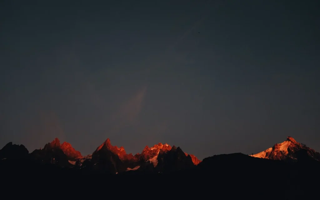 Mountains basking in dim red light from the setting sun