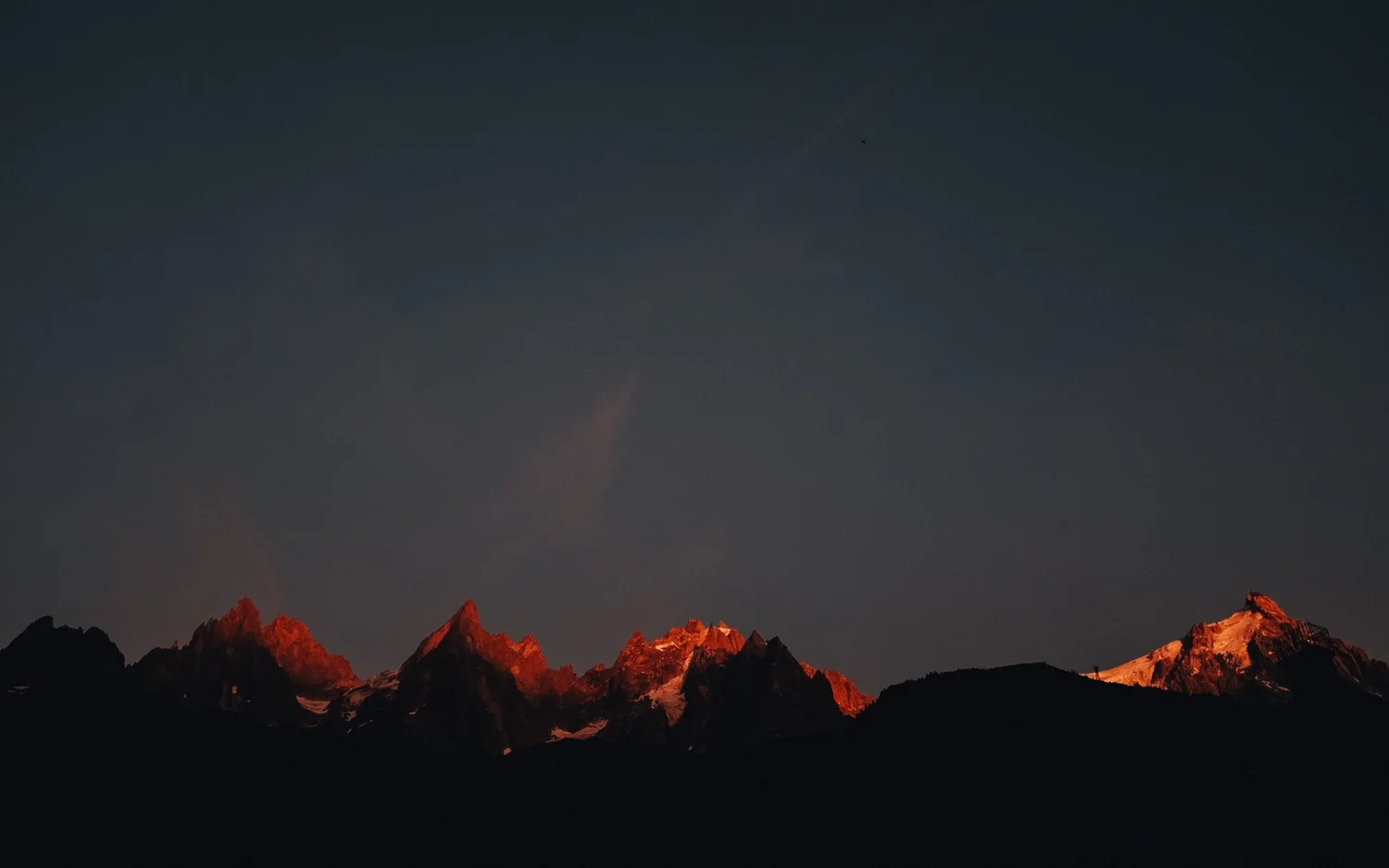 Mountains basking in dim red light from the setting sun
