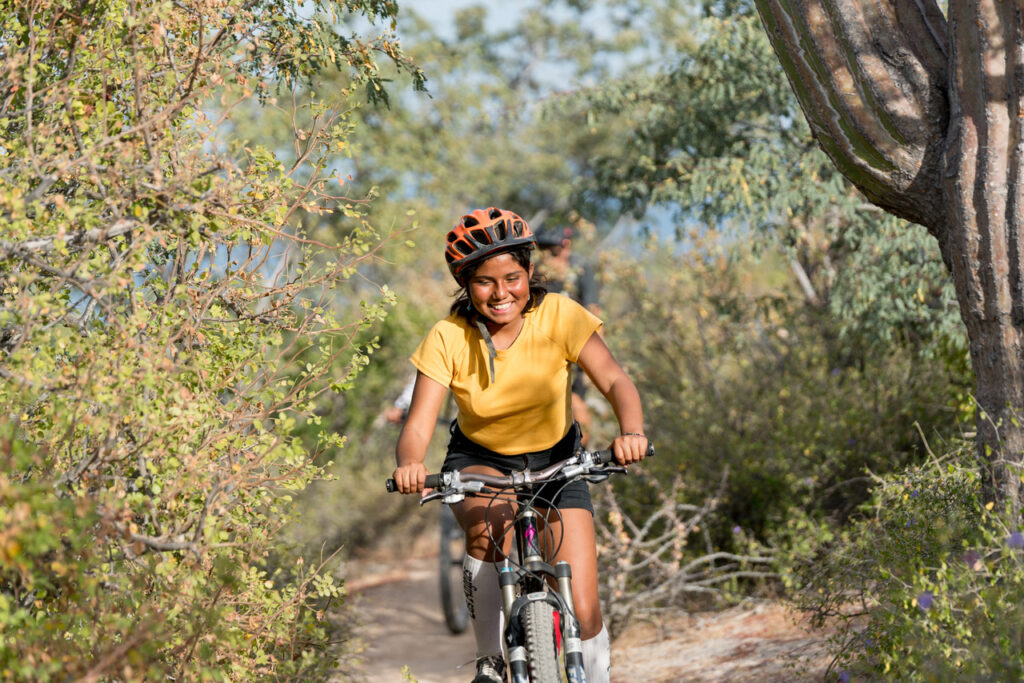 Happy girl riding a mountain bike in Mexico. 